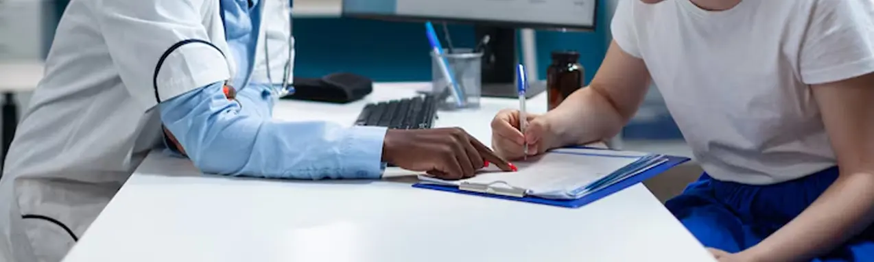 Healthcare professional reviewing assessment forms with a patient during a mental health evaluation