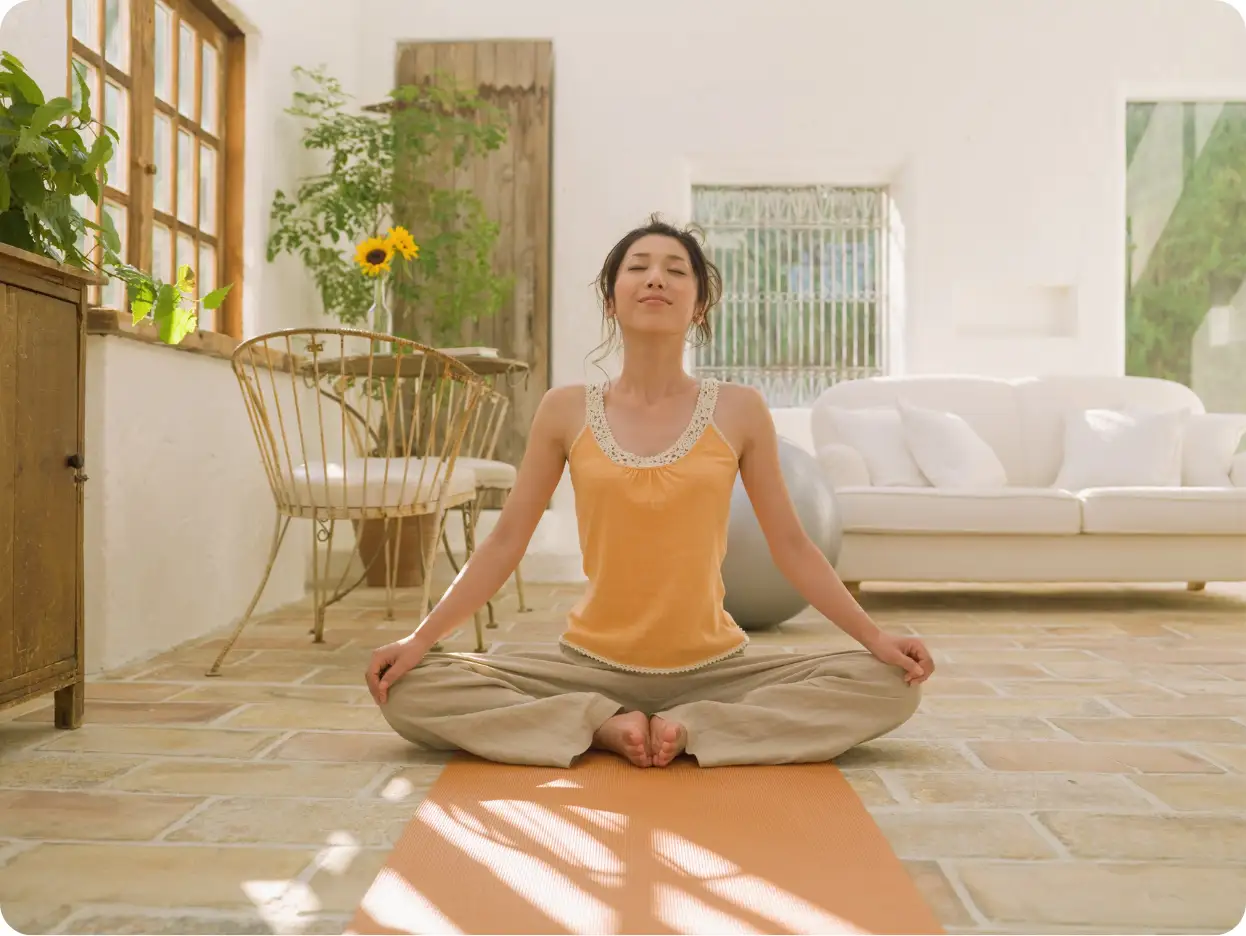 Person meditating in a bright room.